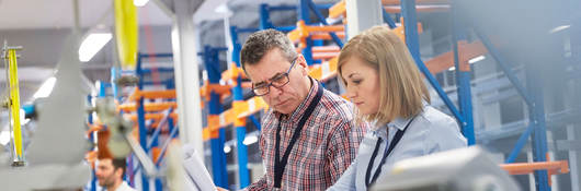 Two people at work looking at printed plans